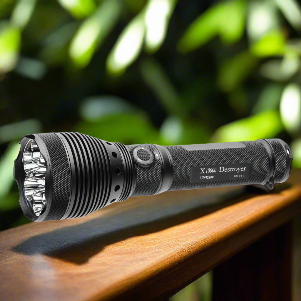 Black flashlight labeled 'X10000 Destroyer' on a wooden surface with green foliage in the background