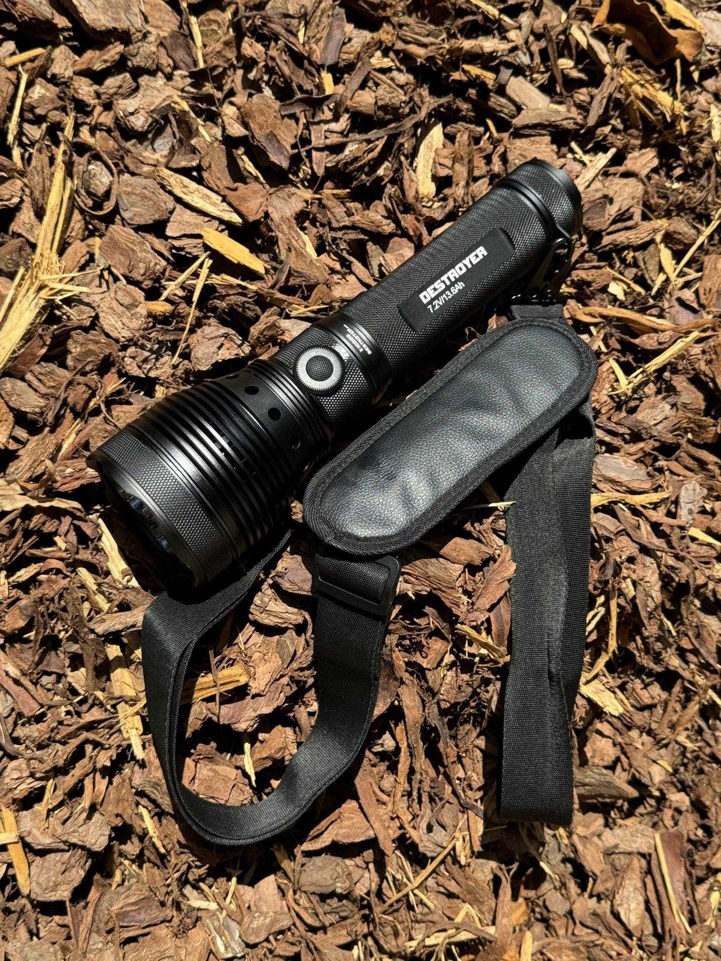 Black flashlight with strap on mulch